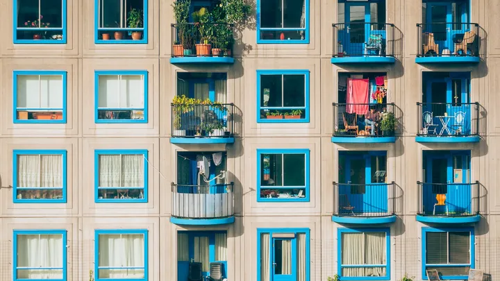 An apartment building facade with rows of balconied windows