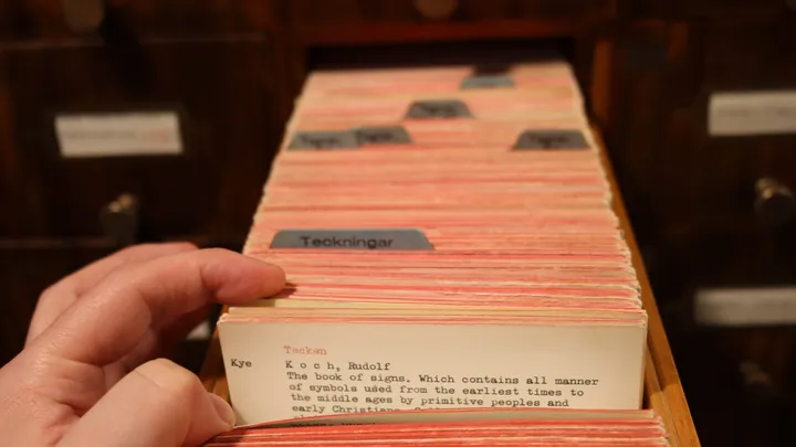 A library card catalog drawer full of index cards