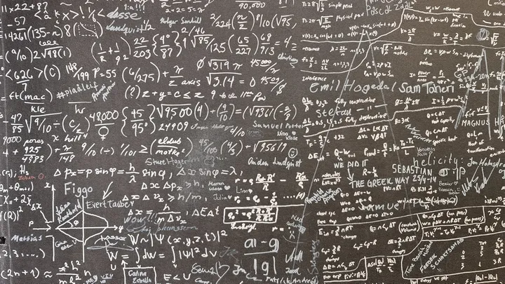 Chalkboard covered in mathematical equations