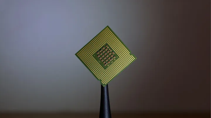 A computer chip held between two fingertips