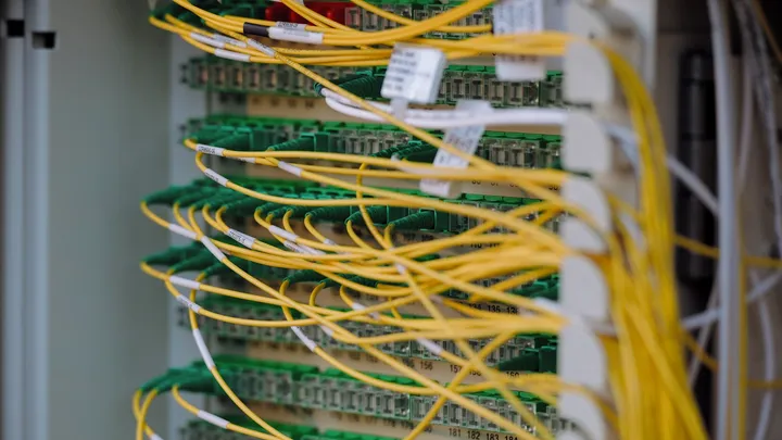 Dense bundles of network cabling running between server racks in a data center hall