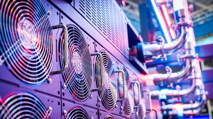 Rows of cooling fans inside a data center hall, the hardware that removes heat from AI servers