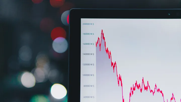 A red stock chart line falling sharply against a dark background