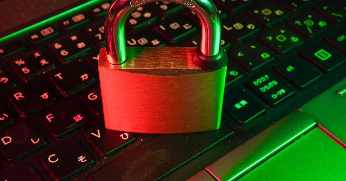 A padlock resting on a keyboard bathed in red light, representing an urgent security patch