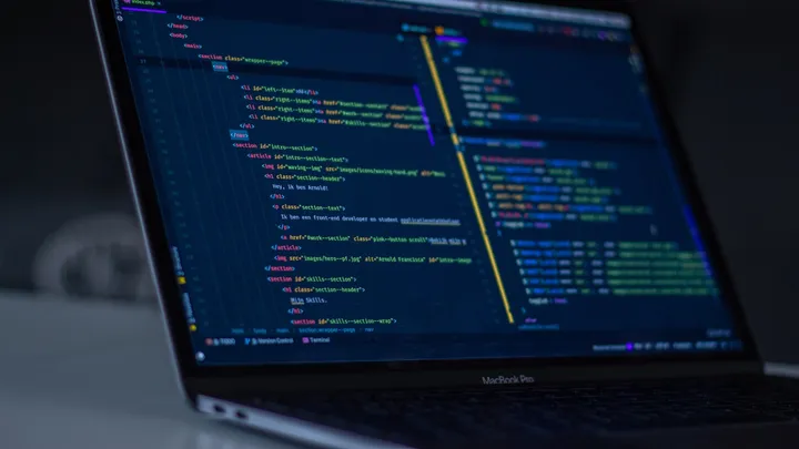 A laptop screen showing code in a dark editor