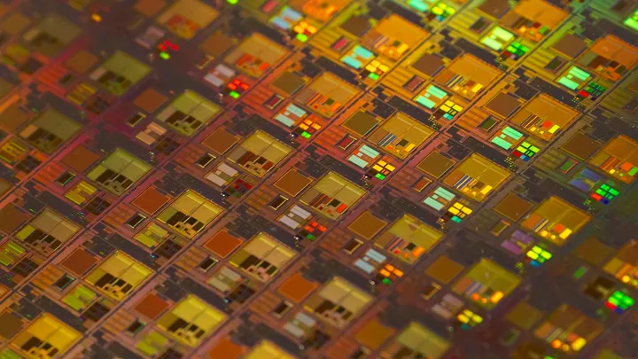 A silicon wafer of semiconductor chips reflecting rainbow light